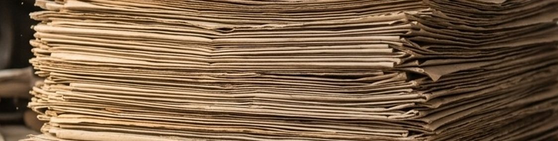 Stacked newspapers seen edge-on